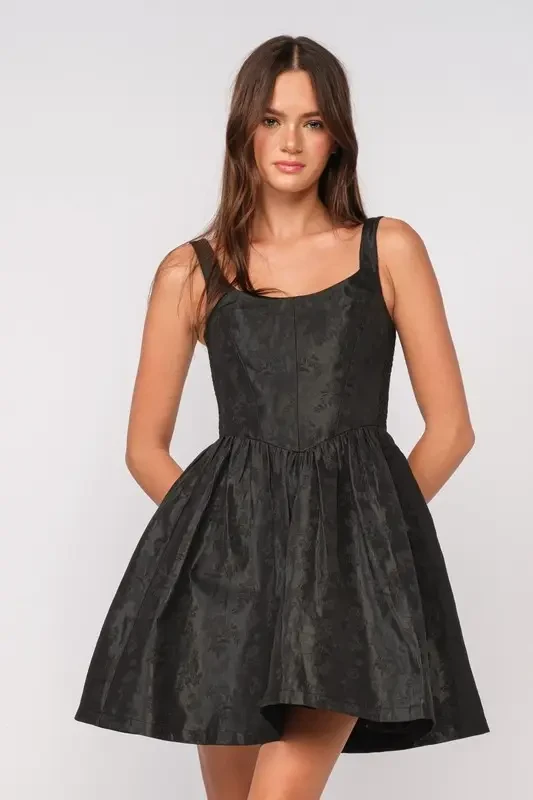 model is wearing a sleeveless black mini dress