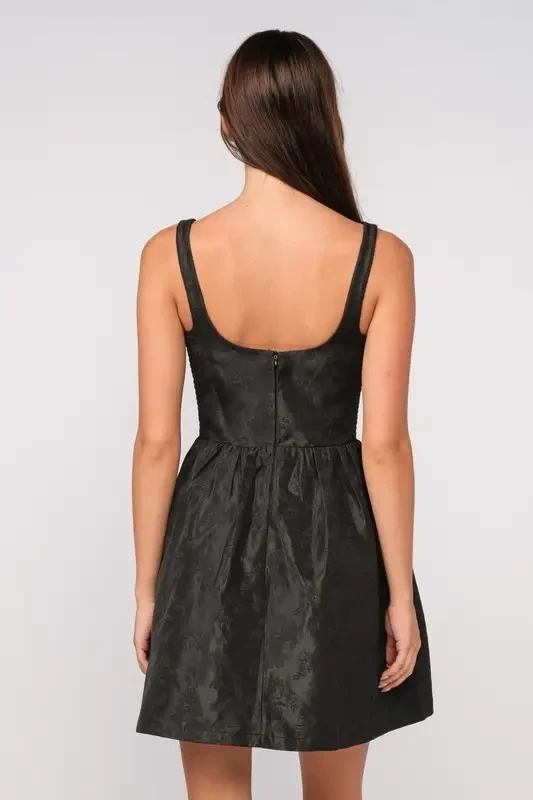 model is wearing a sleeveless black mini dress