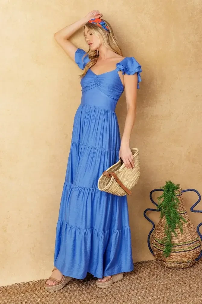 model is wearing a blue a-line evening dress with cap flutter sleeves