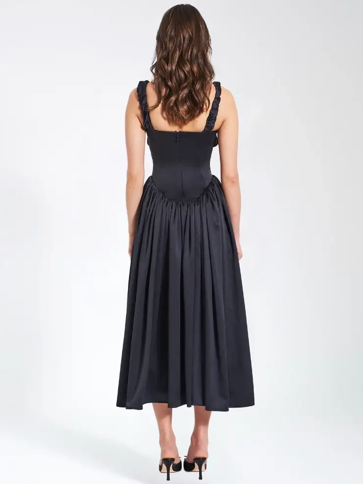 model is wearing a black sleeveless a-line tea length basque waist evening dress